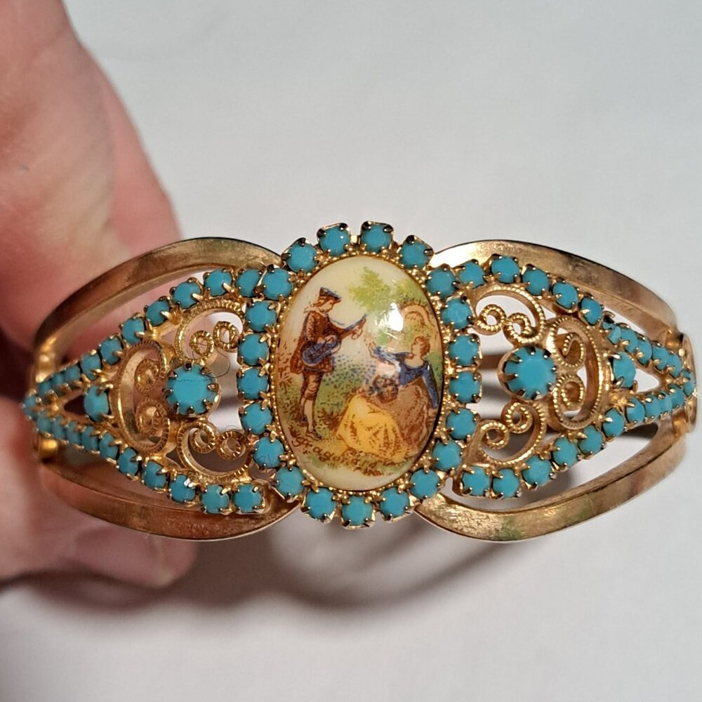 Gold and turquoise color clamper bracelet with romantic scene of man and women
